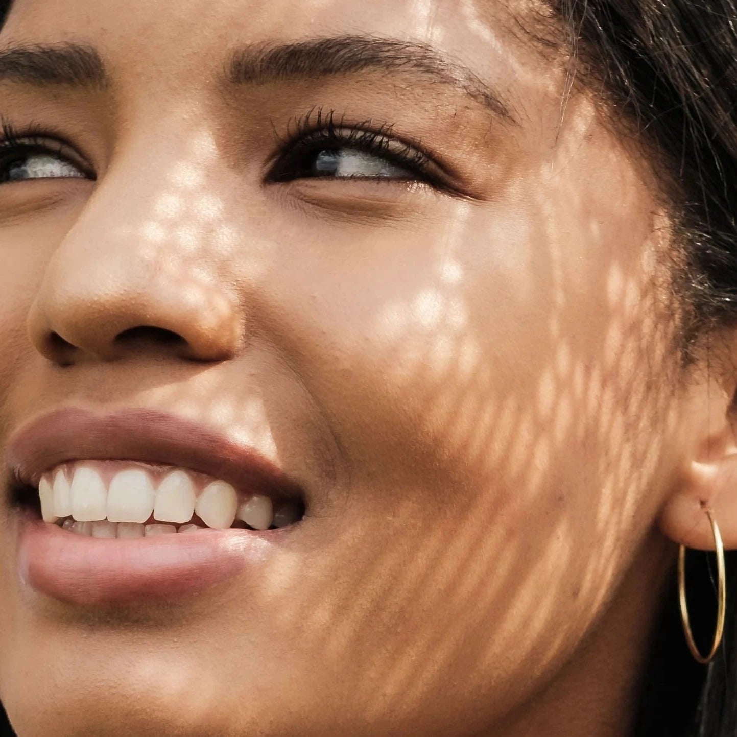 Close-up of a woman's face with a sunlit effect on her skin